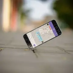 Un cellulare rotto giace a terra, forse è ora di capire dove si buttano i cellulari vecchi per un corretto smaltimento.