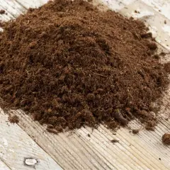 Un cumulo di torba su un tavolo di legno. La torba serve per migliorare il terreno, trattenere l'umidità e favorire la crescita delle piante.