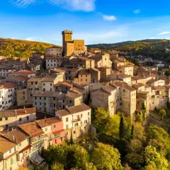 Borgo medievale su una collina, con un castello in cima. Un esempio di albergo diffuso significato, dove le case del paese offrono ospitalità.