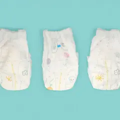 Tre pannolini per bambini con disegni colorati, pronti per essere smaltiti. Ecco dove si buttano i pannolini dei bambini.