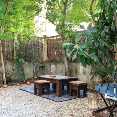 Un angolo zen per il tuo progetto giardino 50 mq: tavolino intagliato, sgabelli, Buddha e cactus.