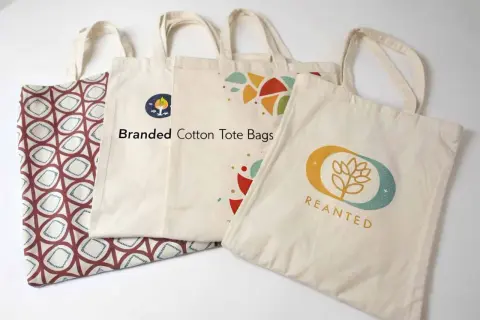 Diverse buste della spesa in cotone, alcune con stampe geometriche e altre con loghi colorati, pronte per lo shopping sostenibile.