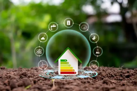 Casa con etichetta energetica e icone di sostenibilità, come pannelli solari e turbine eoliche. Le lastre di cartongesso sono un materiale da costruzione efficiente.