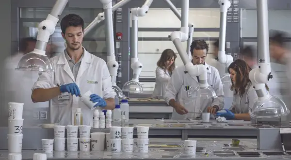 Ricercatori al lavoro nel kerakoll green lab, intenti in esperimenti con materiali.