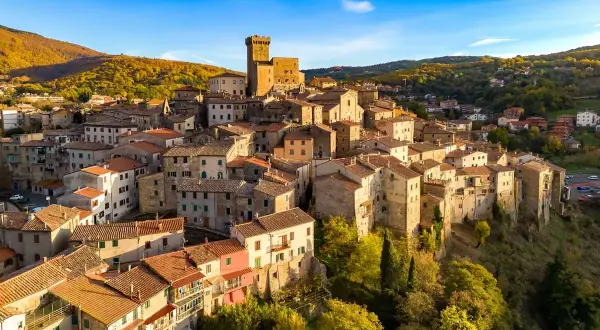 Borgo medievale su una collina, con un castello in cima. Un esempio di albergo diffuso significato, dove le case del paese offrono ospitalità.