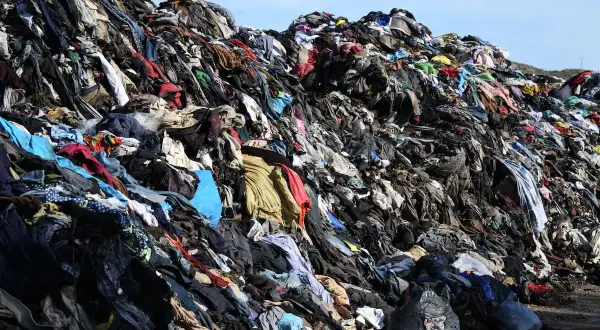 Enorme discarica di vestiti in Cile, un cumulo di abiti usati che forma una montagna di rifiuti tessili.