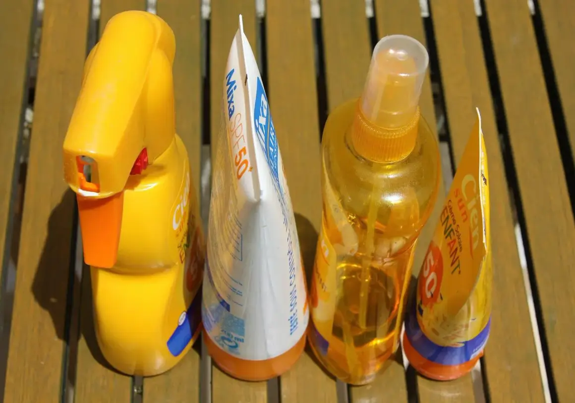 Prodotti solari scaduti, tra cui una crema solare spray e una lozione, pronti per essere smaltiti. Dove si buttano le creme scadute?