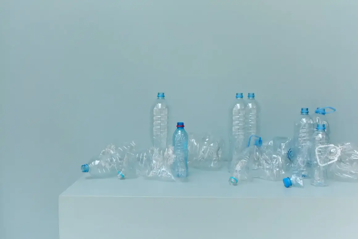 Bottiglie di plastica vuote, alcune schiacciate, su un piano. Un promemoria visivo della necessità di alternative alla plastica.