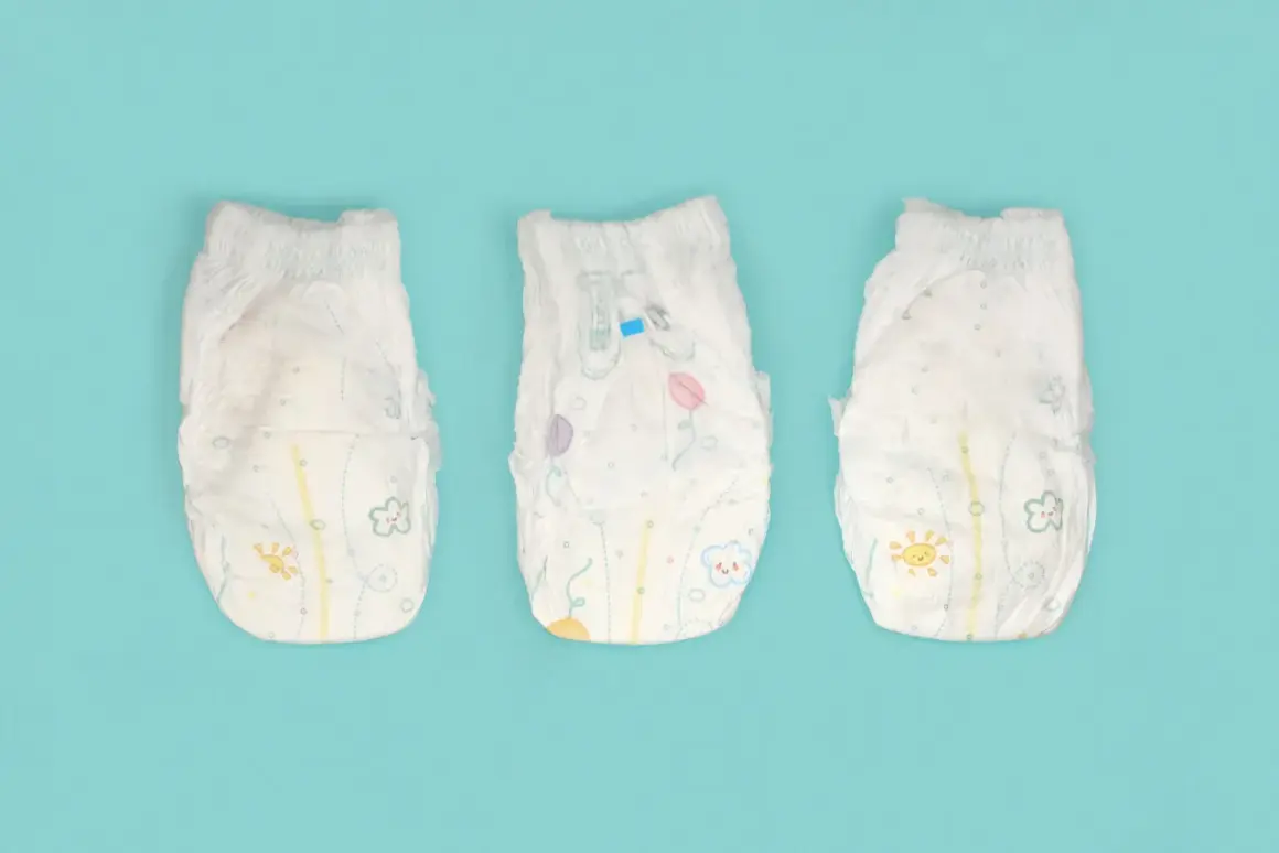 Tre pannolini per bambini con disegni colorati, pronti per essere smaltiti. Ecco dove si buttano i pannolini dei bambini.