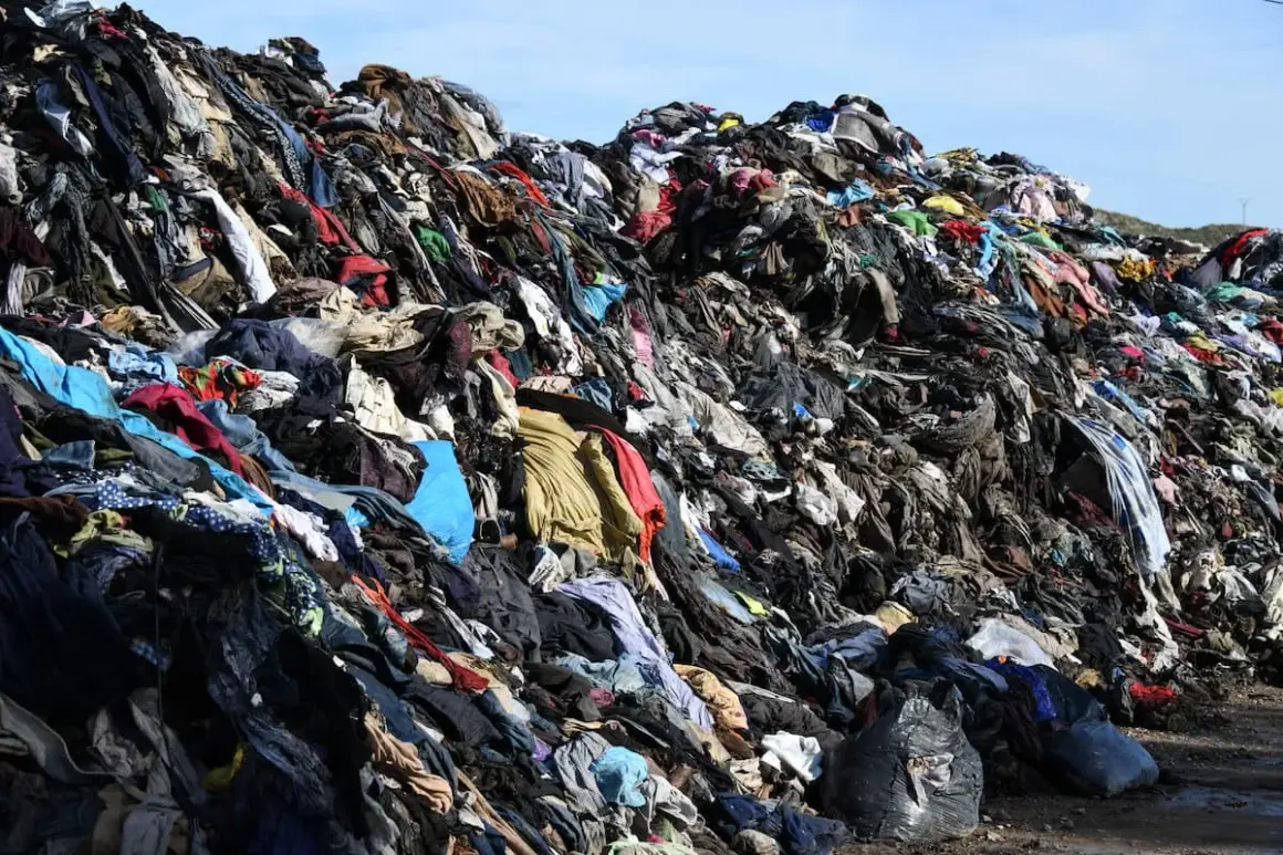Enorme discarica di vestiti in Cile, un cumulo di abiti usati che forma una montagna di rifiuti tessili.