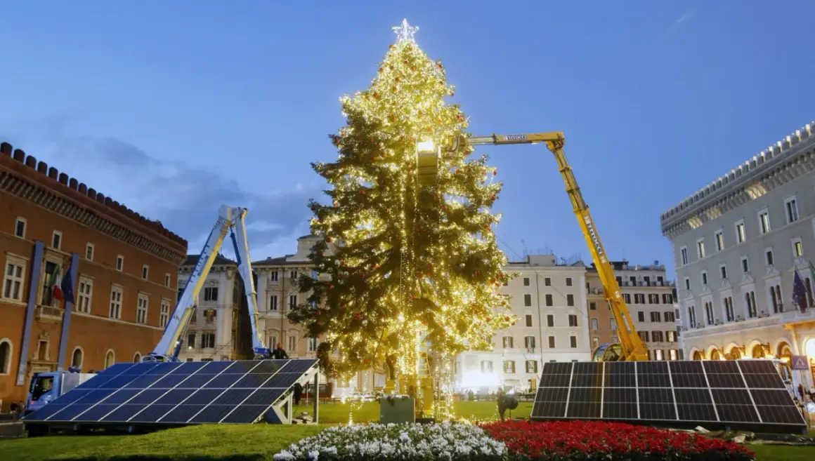 Un imponente albero di Natale illuminato, circondato da pannelli solari, simboleggia un futuro più verde per le festività.