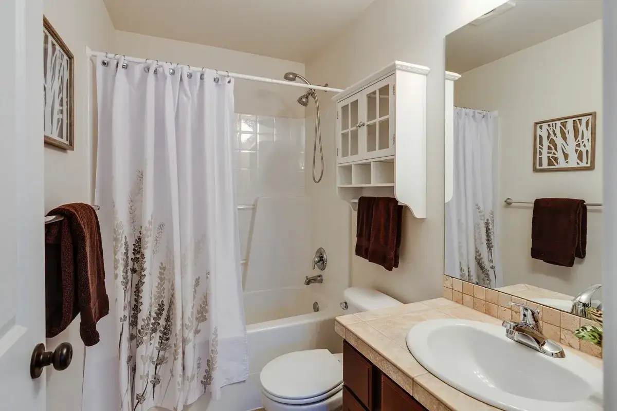 Bagno cieco con doccia, vasca, WC e lavandino. La tenda della doccia ha un motivo floreale. L'aerazione bagno cieco &egrave; garantita da un sistema a scomparsa.