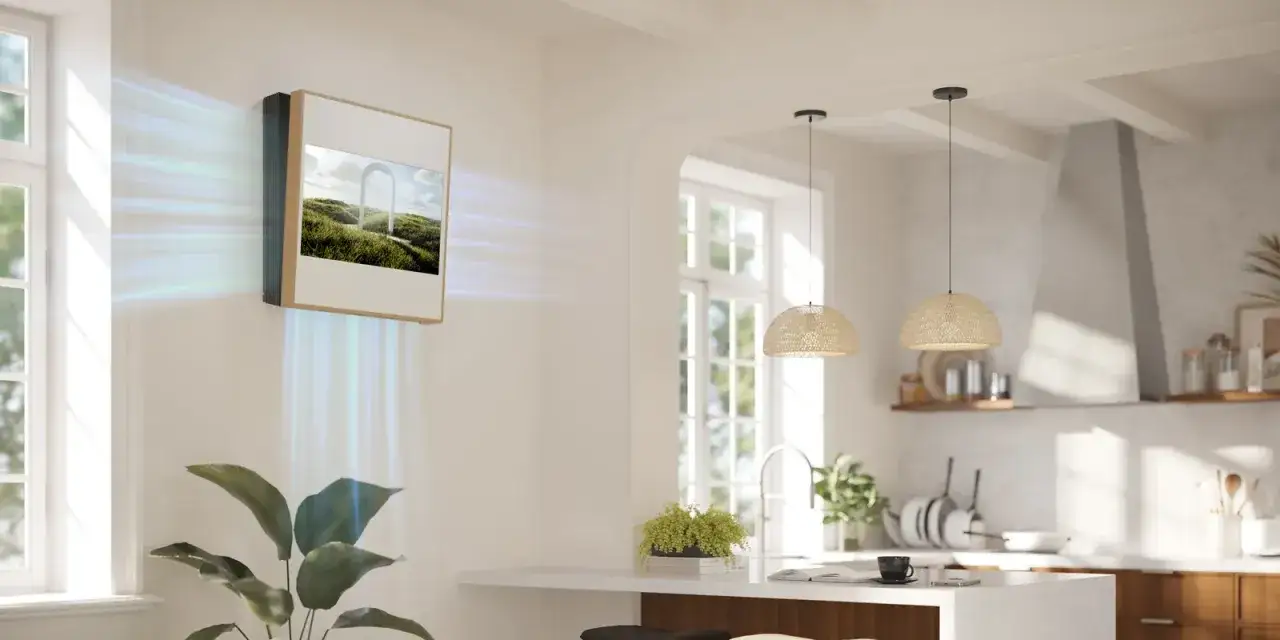 Un'elegante unità split diffonde aria fresca in una cucina moderna. Il dispositivo, con un'immagine di paesaggio sullo schermo, contribuisce al riscaldamento e al raffreddamento dell'ambiente.