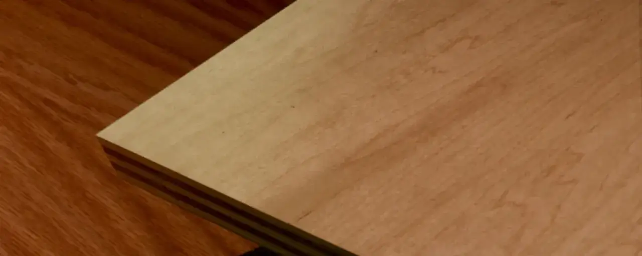 Angolo di un piano in legno chiaro, con venature visibili, su un pavimento in legno scuro. Il legno FSC significato &egrave; sostenibilit&agrave;.