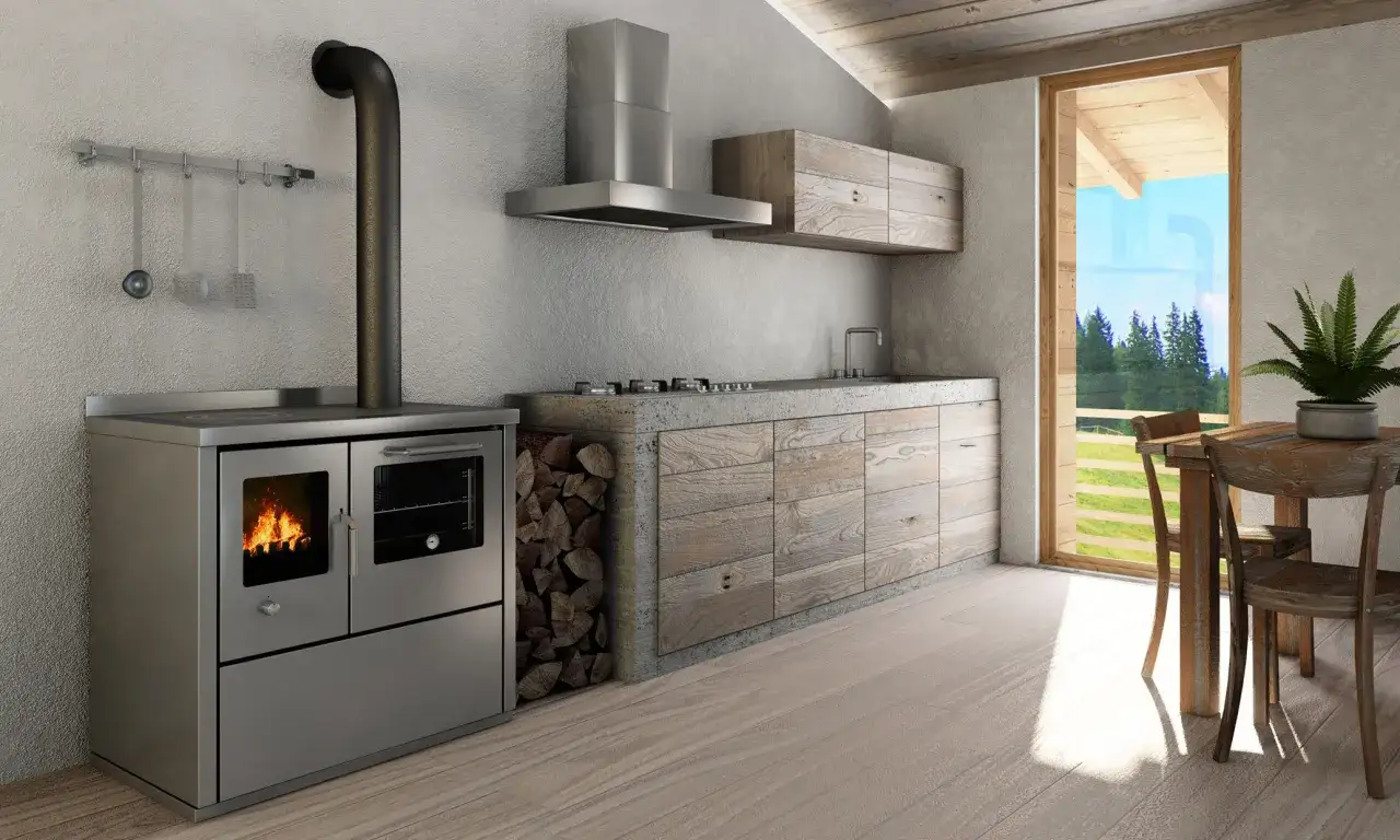 Cucina rustica con stufa a legna accesa, legna da ardere impilata e vista su un paesaggio verde.