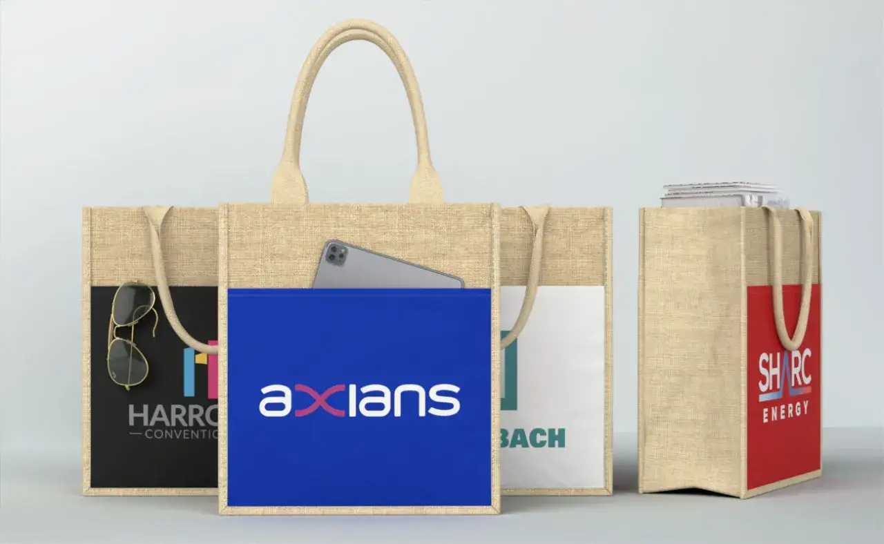 Tre buste della spesa in iuta, una con occhiali da sole e logo, un'altra con smartphone e logo, e una terza con libri e logo.