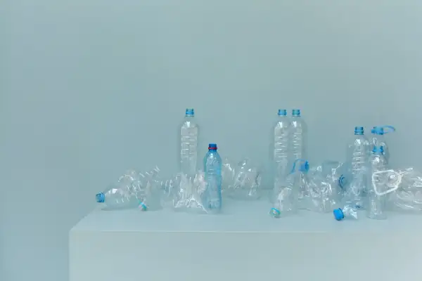 Bottiglie di plastica vuote, alcune schiacciate, su un piano. Un promemoria visivo della necessità di alternative alla plastica.