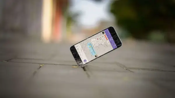 Un cellulare rotto giace a terra, forse è ora di capire dove si buttano i cellulari vecchi per un corretto smaltimento.