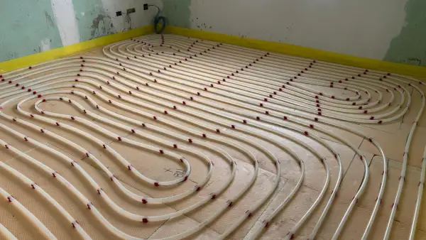 Installazione di tubi per riscaldamento a pavimento su pannelli isolanti. Un sistema efficiente per un comfort domestico.