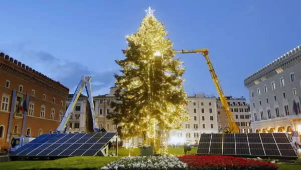 Un imponente albero di Natale illuminato, circondato da pannelli solari, simboleggia un futuro più verde per le festività.
